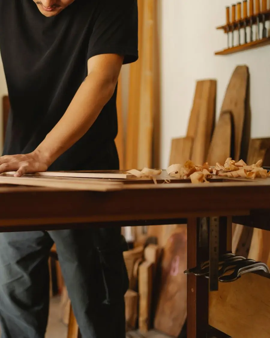 Artisan travaillant une pièce de bois sur un établi