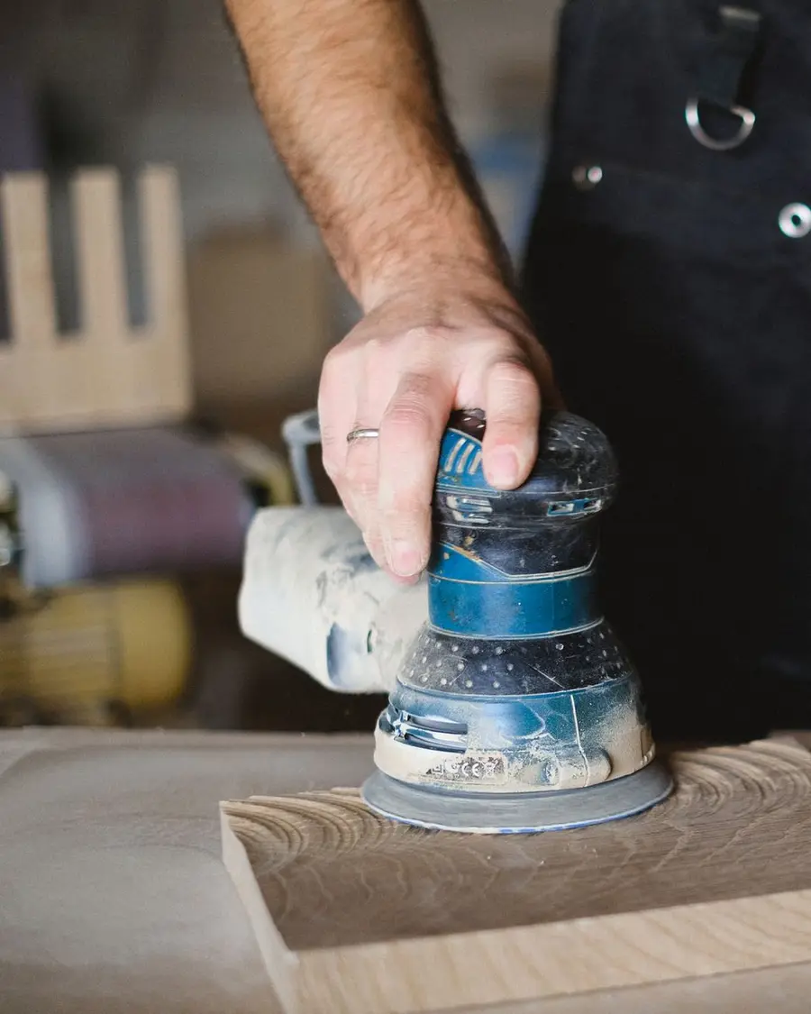 Artisan ponçant une planche de bois